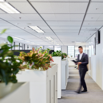 Employee in the Hong Kong office walking near workstations.