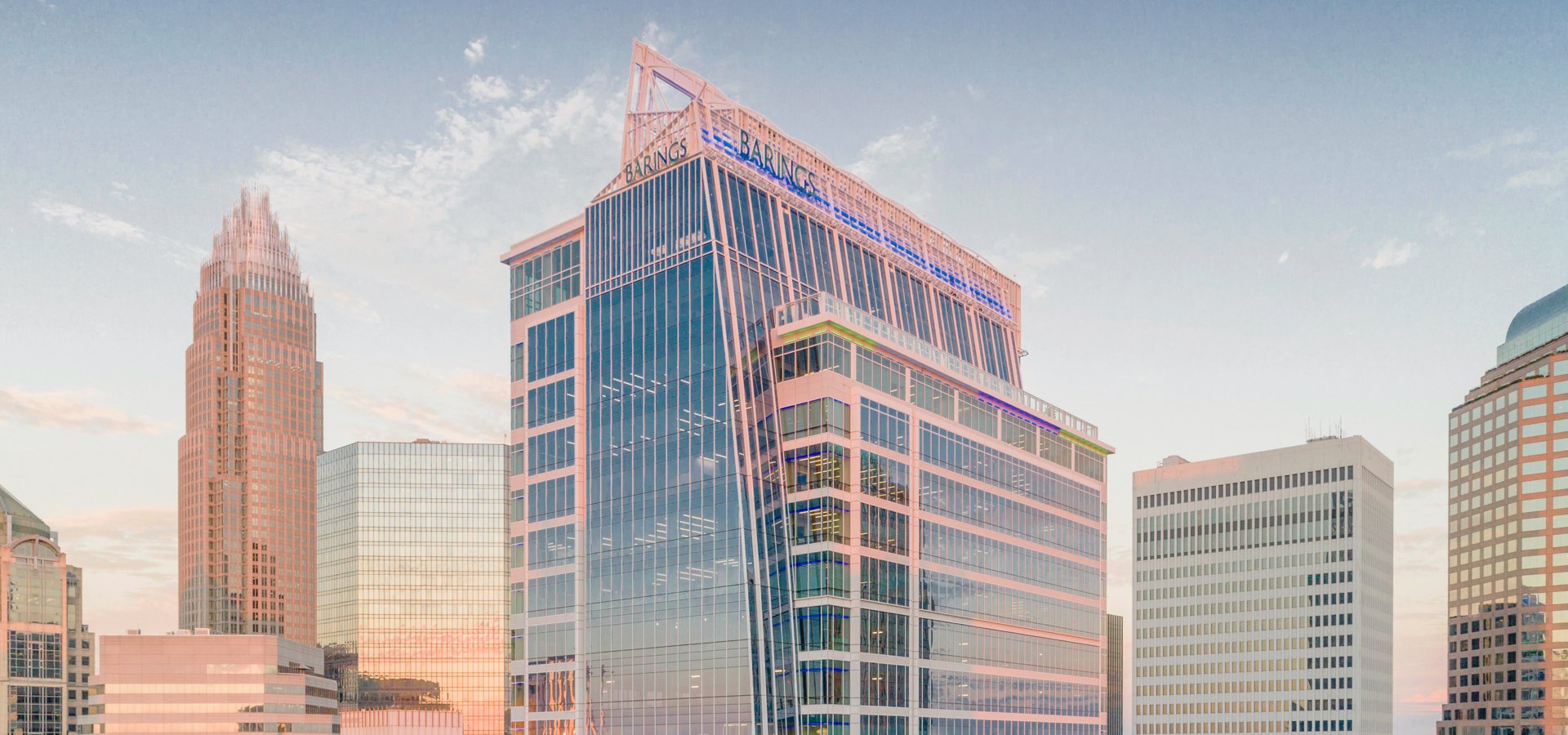 Skyline view of Barings headquarters building in Charlotte, North Carolina at twilight.