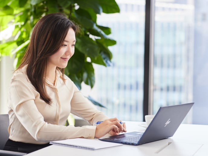 Person sitting with a laptop in an office.