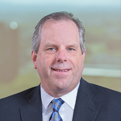 Headshot of Tim Kenny smiling at the camera.