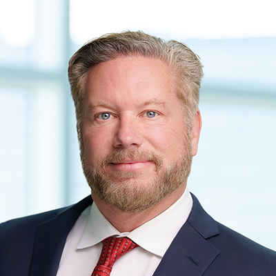 Headshot of Tom McDonnell smiling at the camera.