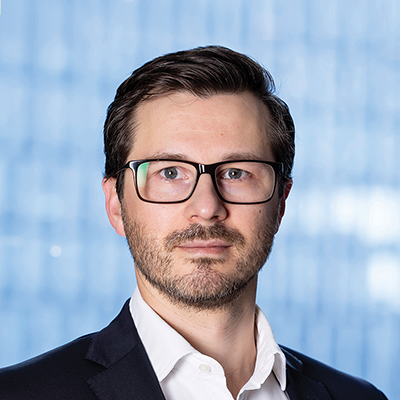 Headshot of Maksim Mikrukov smiling at the camera.