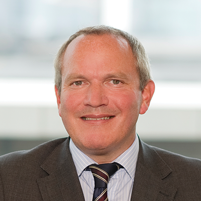 Headshot of Ian Mayhew smiling at the camera.
