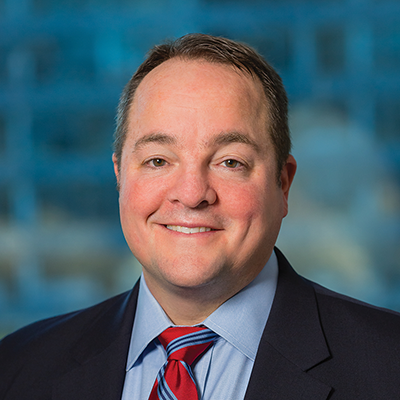 Headshot of Andrew Plunkett smiling at the camera.