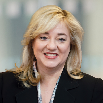 Headshot of Elena Walsh smiling at the camera.
