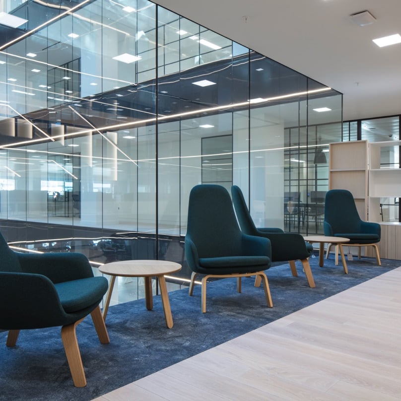 Beautiful atrium in our London office with blue velvet chairs for discussions.