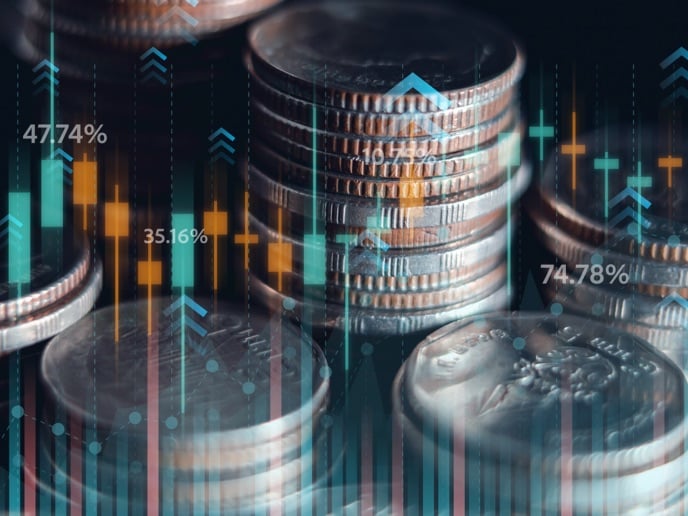 Stacks of coins with overlaid digital charts and percentage indicators representing investment performance and market growth.