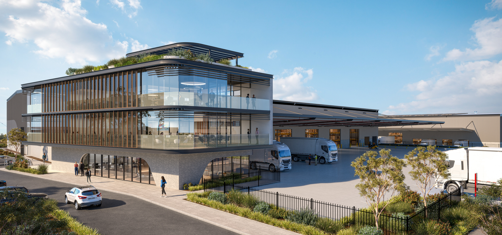 A glass industrial building with trucks in the bays.
