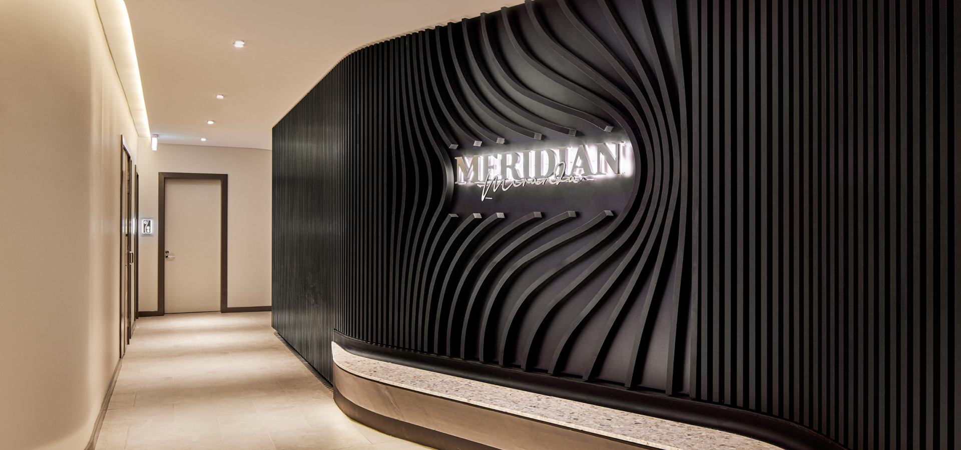 A black wall with the Meridian logo. 