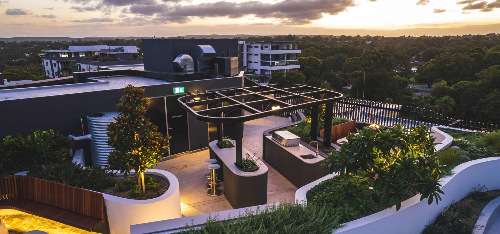 A rooftop garden with trees and a building.