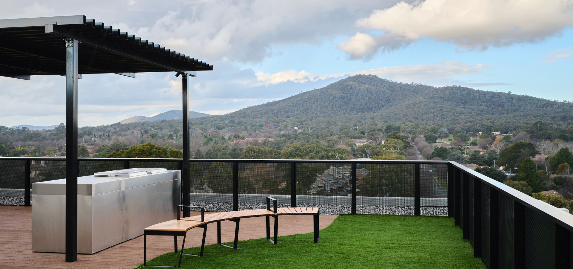 A outdoor deck with a view of mountains and trees.