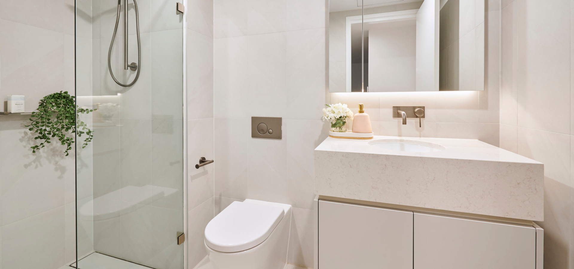 A bathroom with a shower, sink and toilet.