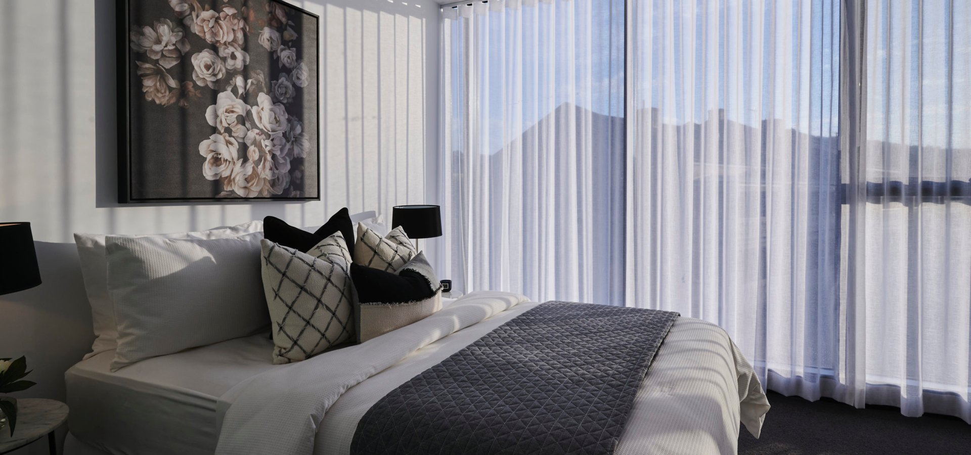 A bed with pillows and a painting on the wall.