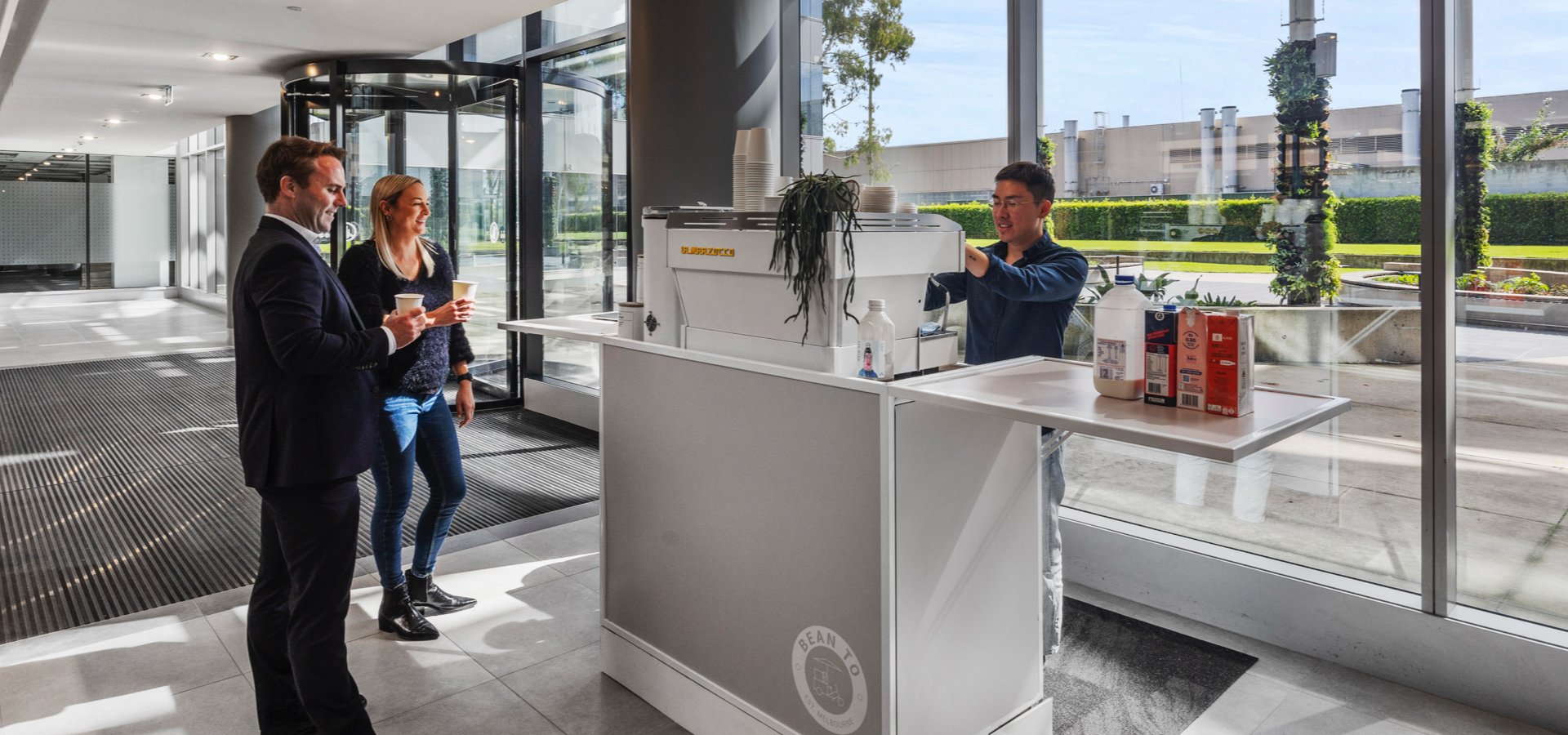 A group of people standing at a coffee counter.