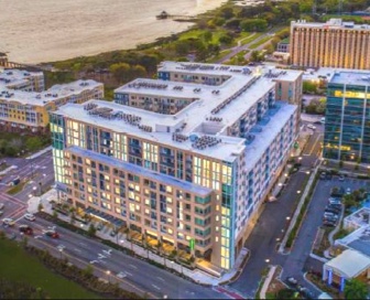 Aerial view of a mid-sized, brick, tan residential building at sunset.
