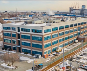 A four-story, tan and blue brick office building. 