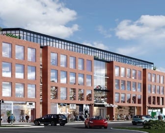 A five-story, red, brick mixed-use building with people and cars in front of it.  